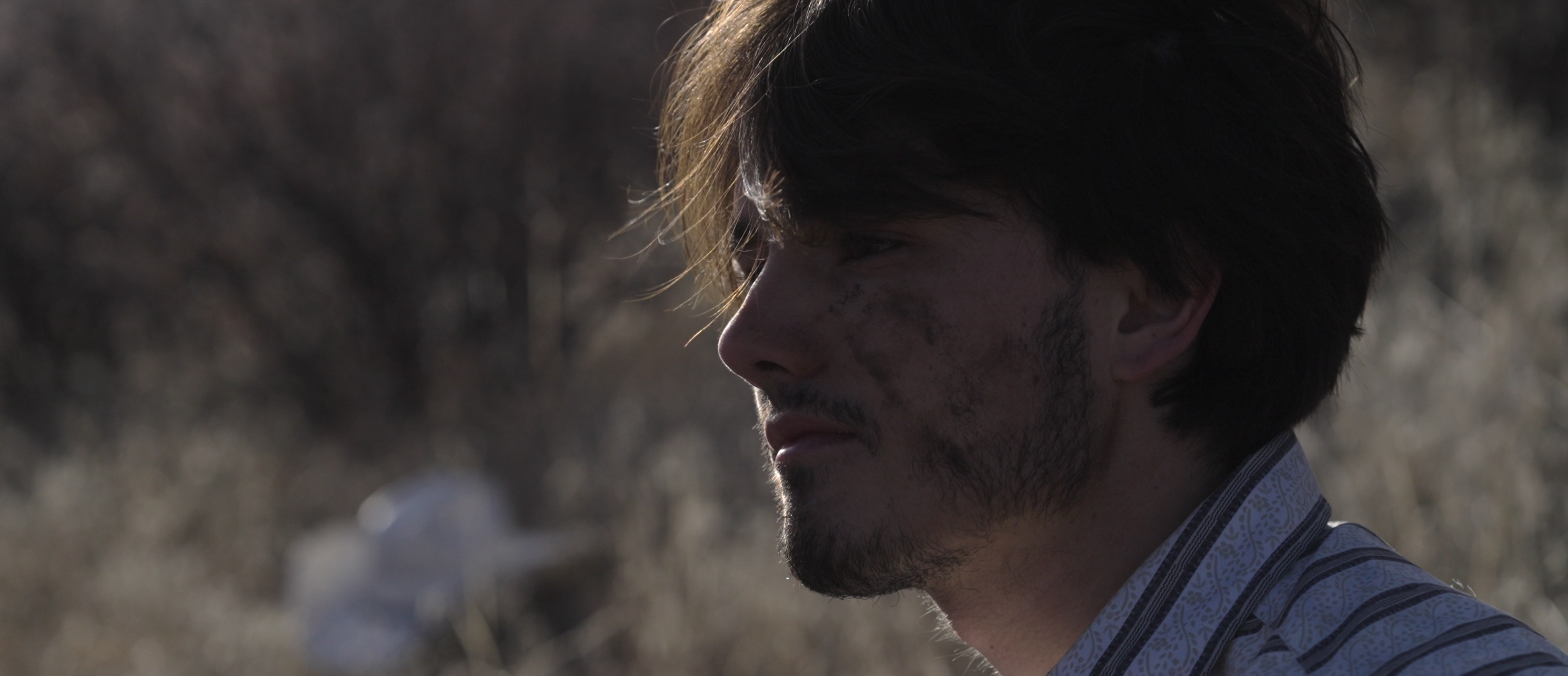 Under the Gila still, close profile portrait with dirt on face
