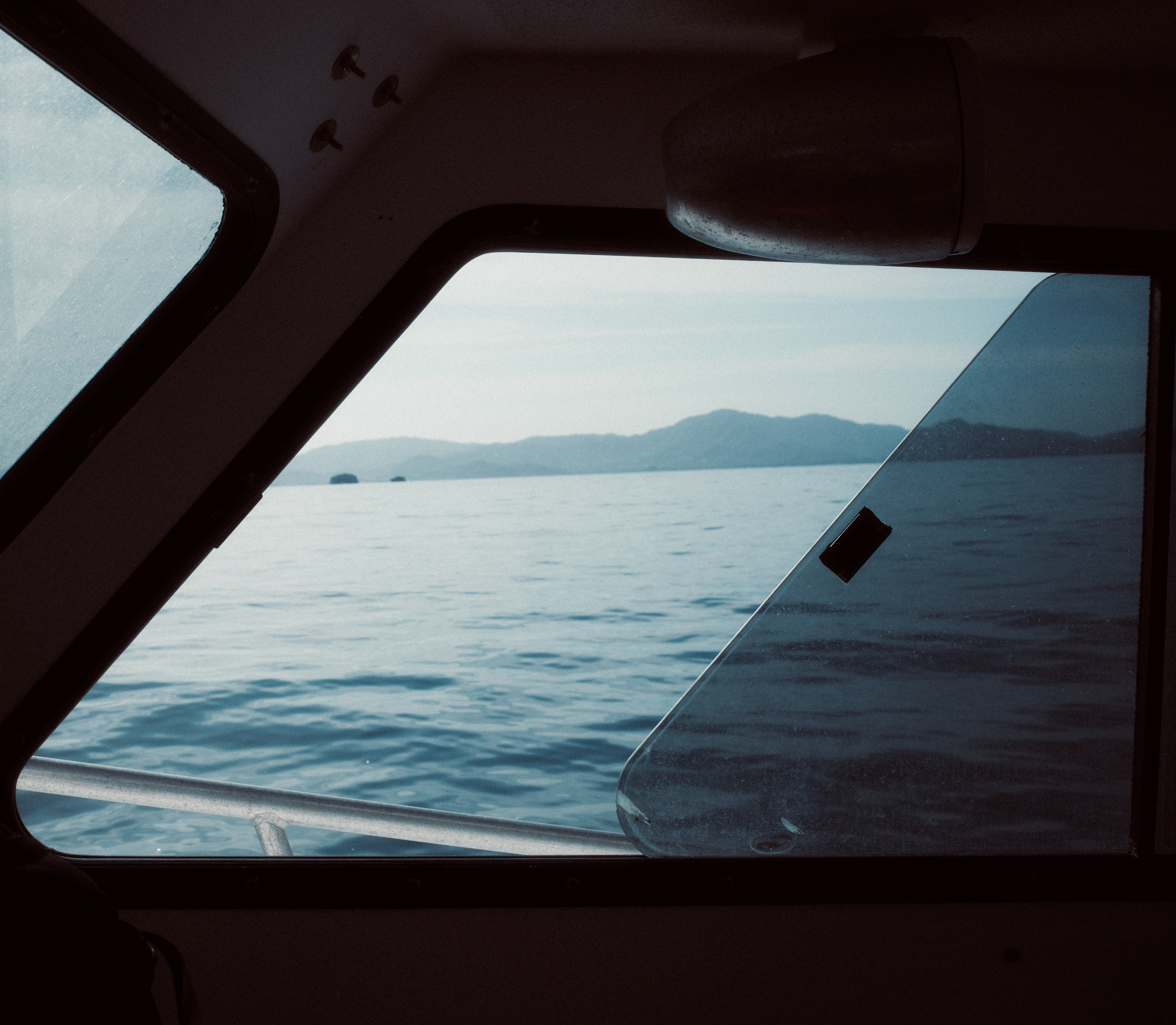 View of the ocean and mountains through a boat window